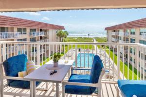 a balcony with a table and chairs and the beach at Spanish Main in Cocoa Beach