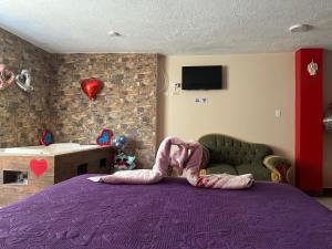 a person laying on a purple bed in a bedroom at Hospedaje la Cascada in Riobamba