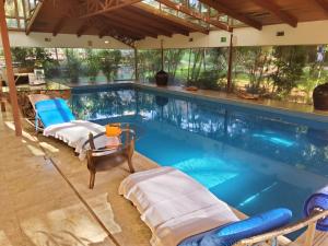 a swimming pool with two beds and a table and chairs at Hotel & Spa Quinta Sauz in Tacámbaro de Codallos