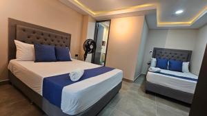 麦德林Hospedaje Andaliving Campo Valdes的一间卧室，有两张床，配有蓝色和白色的枕头