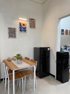 Il comprend une cuisine équipée d'une table et d'un réfrigérateur noir. dans l'établissement SIJI Homestay Purwokerto, à Purwokerto