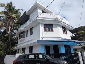 a black car parked in front of a white building at Sankeerthanam - Lounge in serenity in Cochin