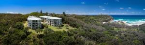 an aerial view of a building on a hill next to the ocean at Whalewatch Ocean Beach Resort in Point Lookout
