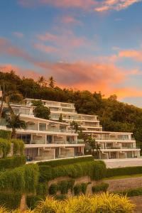 ein großes weißes Gebäude mit Bäumen im Hintergrund in der Unterkunft The View Kata Karon in Kata Beach + 30 Fotos
