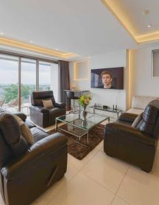 ein Wohnzimmer mit 2 Ledersofas und einem TV in der Unterkunft The View Kata Karon in Kata Beach