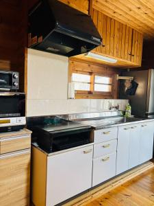 a kitchen with white cabinets and a stove top oven at ISE Family Cabin in Ise +8 photos