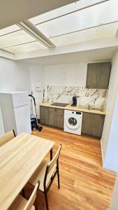 a kitchen with a table and a washing machine at Maison partagée 4 chambres Saint Roch Roubaix in Roubaix