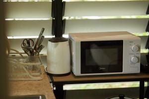 a microwave sitting on top of a kitchen counter at Amazing Mountain View Lodge with Pool in Kuala Kubu Baharu
