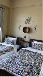 a bedroom with two beds with blue and white sheets at Nich Houses Craft&More in Sathani Sala Ya