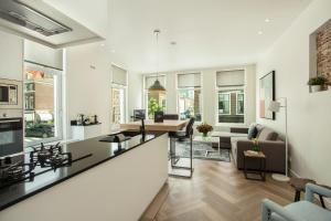a kitchen and living room with a bar and a living room at Stayci Serviced Apartments Denneweg in The Hague