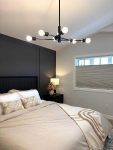 a bedroom with a large bed with a black headboard at Cozy Heaven in Saskatoon