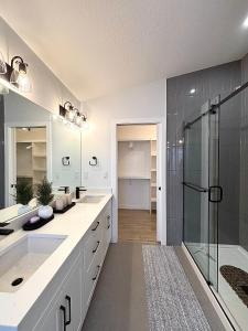 a bathroom with two sinks and a shower at Cozy Heaven in Saskatoon