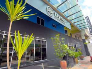 a building with a palm tree in front of it at Living At DSulaiman Hotel in Kuala Lumpur