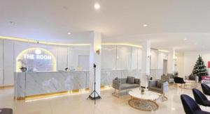 a lobby with couches and a counter in a building at The Room Hotel in Ban Nong Puk
