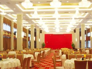 a banquet hall with tables and chairs and a red wall at Quanzhou Royal Prince Hotel in Quanzhou