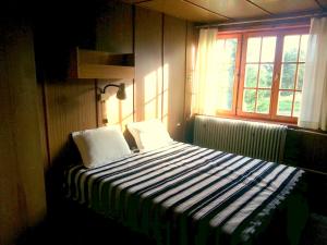 um quarto com uma cama com duas almofadas e uma janela em Chata Salaš em Mlynčeky