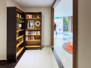 a hallway with book shelves and a person walking in the distance at Living At DSulaiman Hotel in Kuala Lumpur
