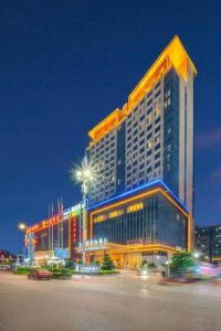 a large building is lit up at night at Golden Phoenix International Hotel in Xiahuangtang