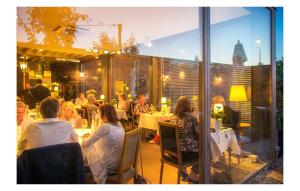 een groep mensen die aan tafel zitten in een restaurant bij Hotel Restaurant Vous lé Vous in Hasselt