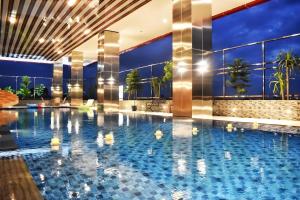 a large swimming pool in a hotel with lights on at Grand Metro Hotel Tasikmalaya in Tasikmalaya