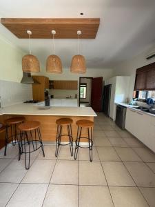 塔马兰Golf near the beach的房间里有带柜台和凳子的厨房