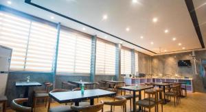 un restaurant avec des tables et des chaises dans une salle dans l'établissement Chonpines Hotel Shenzhen Gongming Honghuashan Metro Station, à Xitian