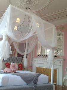 1 dormitorio con cama con dosel y cortinas blancas en Boavista Eco-Luxury House, en Oporto