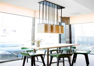 a dining room with a table and green chairs at City Comfort Inn Xianning Tongshan Education Bureau in Tongshan
