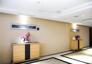 - un hall avec deux comptoirs avec des fleurs dans l'établissement City Comfort Inn Jingzhou Railway Station Fantawild, à Caoshi