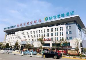 Un grand bâtiment blanc avec un panneau en haut dans l'établissement City Comfort Inn Jingzhou Railway Station Fantawild, à Caoshi