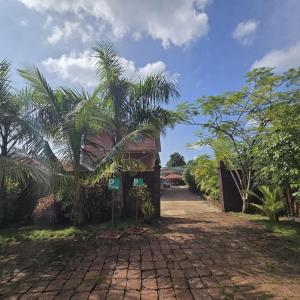 una casa con una palma accanto a una strada di Natures Harmony Resort a Polem