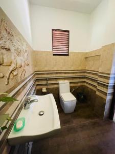 a bathroom with a sink and a toilet at Suzzi Villa in Weligama