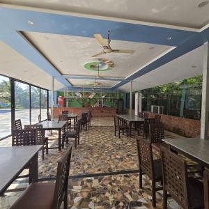 un ristorante con tavoli e sedie e un ventilatore a soffitto di Natures Harmony Resort a Polem