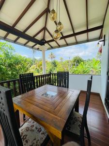 a wooden dining table and chairs on a deck at Suzzi Villa in Weligama