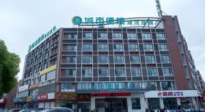 un grand bâtiment avec une enseigne au sommet dans l'établissement City Comfort Inn Taizhou Wanda Plaza, à Taizhou