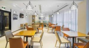 une salle à manger avec des tables et des chaises dans un restaurant dans l'établissement City Comfort Inn Taizhou Wanda Plaza, à Taizhou