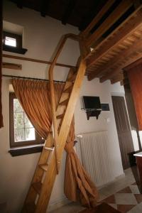 a loft bed in a room with a staircase at Archontiko Pantou in Portariá