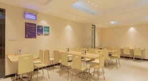 a dining room with tables and chairs in a room at City Comfort Inn Liuzhou Wuxing Walking Street in Liuzhou