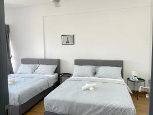 a bedroom with two beds with white sheets at Tropicana 218 Macalister in George Town