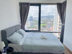 a bed in a room with a large window at Tropicana 218 Macalister in George Town