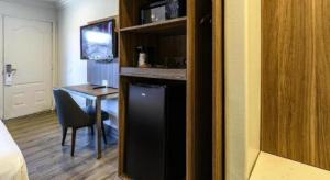 a room with a bed and a desk with a chair at Rodeway Inn Carlsbad in Carlsbad