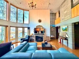 Una sala de estar con un sofá azul y una chimenea. en 逸居&海音#200平方海景别墅#小樽步行街浪漫街附近#冬季免费停放1台车#房间配有空调#暖气, en Otaru
