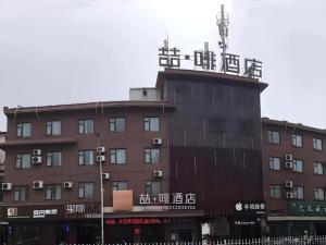 a building with an antenna on top of it at James Joyce Coffetel Xuzhou Feng County Huadi Street in Feng