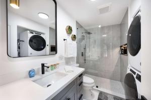 a white bathroom with a sink and a shower at Brand New 2BR Queen Anne Condo Designer's Taste in Seattle