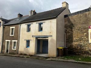 ein altes Steinhaus mit einer Garage in der Unterkunft La Caverne Bretonne in Renac