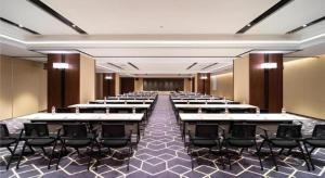 a room with rows of tables and black chairs at Echarm Hotel Shenyang Zhongjie North Station Metro Station in Shenyang