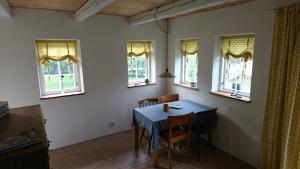 - une salle à manger avec une table, des chaises et des fenêtres dans l'établissement Lillan, à  Torna Hällestad