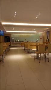 a dining room with tables and chairs and a kitchen at City Comfort Inn Hengyang Jiefang Avenue Business Walking Street in Hengyang