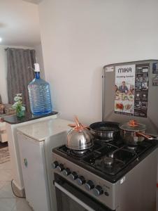 Una cocina con estufa y una botella de agua. en Cynergy 1b Apartment, Muthiga , Waiyaki Way, en Nairobi