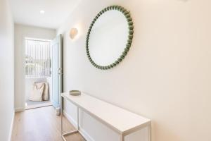 芬加尔湾Ornos, 1-14 Market St - ducted air con, cot, highchair, Linen and Bed Making的白色的房间,墙上有镜子 更多15张照片